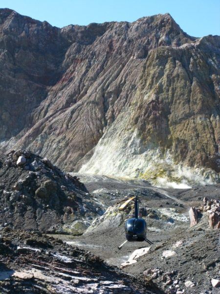 Our Volcanic Air Safaris helicopter parked on White Island surrounded by majestic volcano scenery 