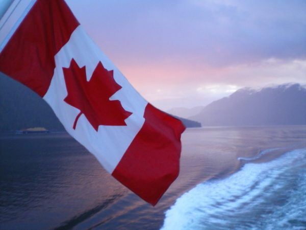 Canadian flag against sunset and water