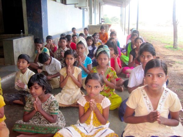 Kids at prayer in India; photo by Nomadic Chick