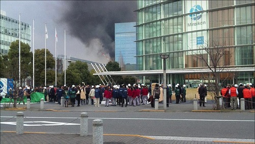 The big earthquake in Tokyo Japan, people standing around and a building on fire