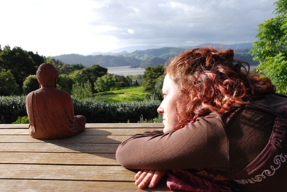 Nora Dunn, The Professional Hobo, chillin with a buddha at Mana Retreat Centre in Coromandel, New Zealand