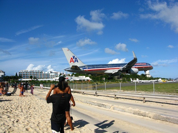 an American Airlines airplane just clears the beach at the end of the runway in St Martin