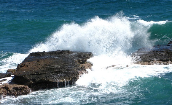 ocean wave crashing over rocks