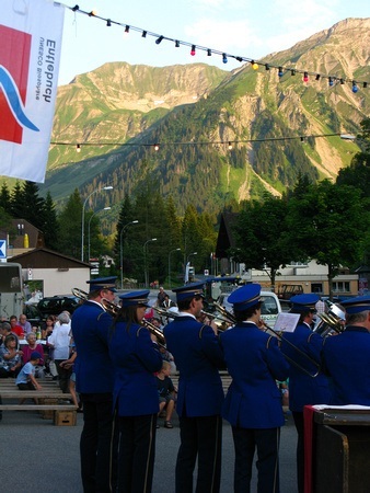 the band plays on with mountains in the background