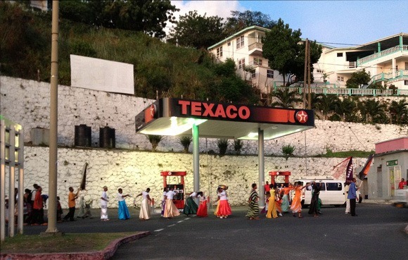 Colourful Grenada - people Parading in front of Texaco