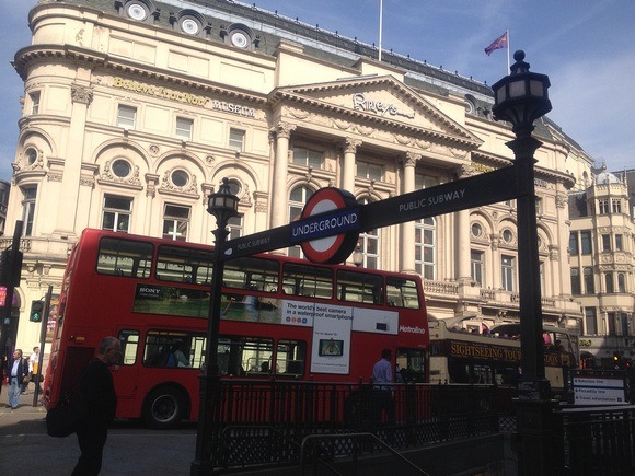 London double decker bus behind Underground sign