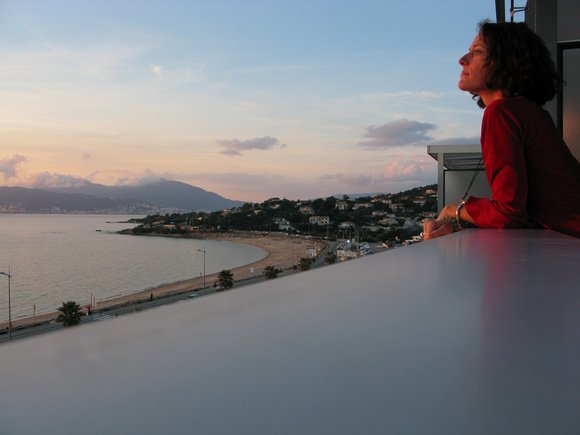 Nora Dunn, The Professional Hobo, watching the sunset over the ocean in Corsica