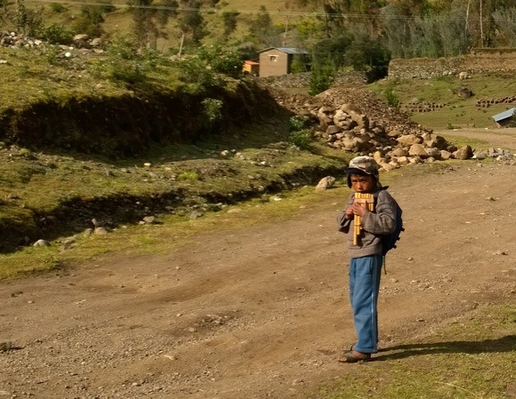 Quechua boy playing a pan flute at Kinsa Cocha town