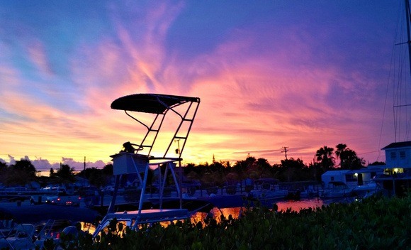 colourful sunset with a boat fishing tower