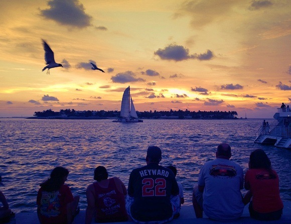 watching the sunset over the ocean with a sailboat and seagulls, in Key West, Florida Keys