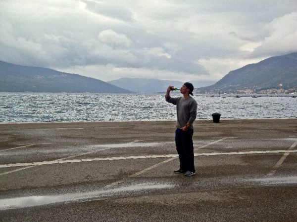 Drew of The Hungry Partier, drinking in Montenegro by the sea