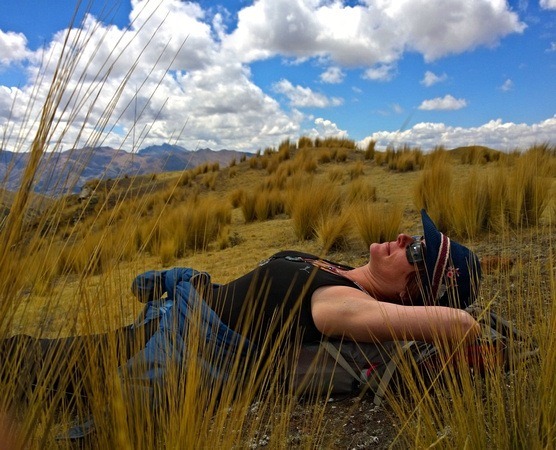 Nora Dunn, The Professional Hobo, lying in the grass while hiking in the Andes of Peru