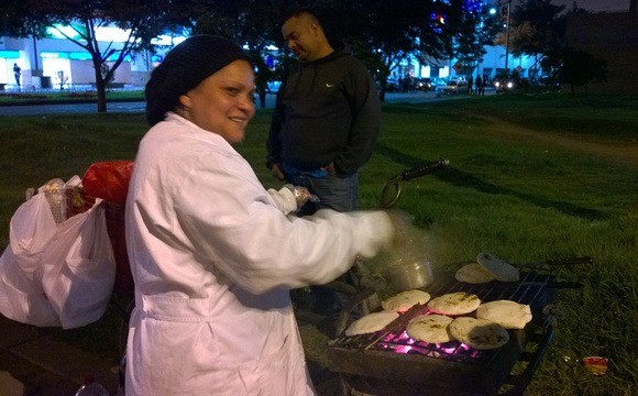 Fast food in Colombia includes arepas, seen here being made on the side of the street