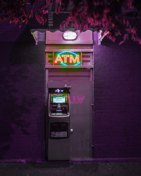 An ATM at night - how to avoid currency conversion fees while traveling