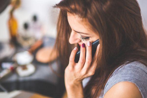 Woman talking on phone - Ways to Stay in Touch While Traveling