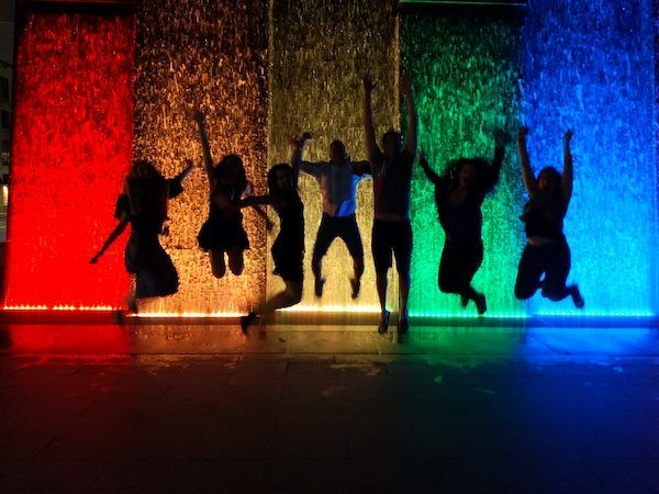 Boston, jumping in front of rainbow water fountain at night