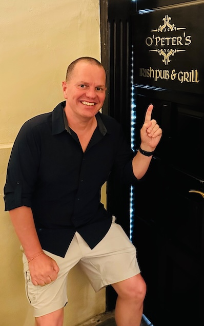 Matt Wald, wearing a lightweight button down and shorts, says you can look good without spending a fortune on travel clothes