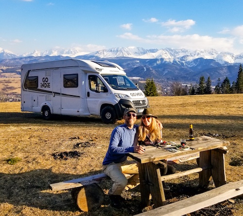 Mike and Anne Howard of HoneyTrek in the Carpathian Mountains with an RV