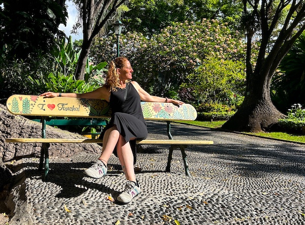 Nora Dunn of The Professional Hobo, sitting on a bench that says I Love Funchal